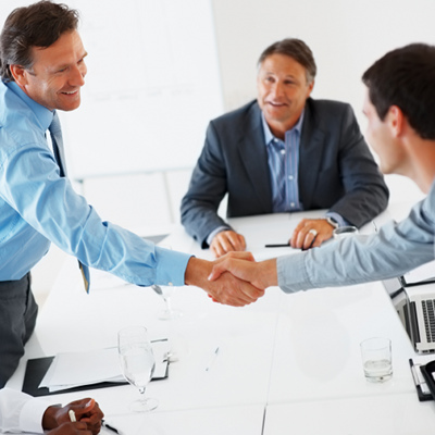 Two businessmen shaking hands, just having concluded a deal.